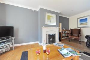 a living room with a fireplace and a tv at Springhill Cottage in Lyme Regis