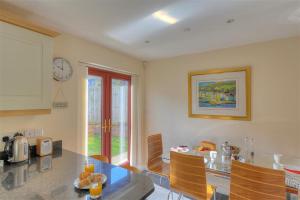 a kitchen with a counter and a table and a clock at Springhill Cottage in Lyme Regis