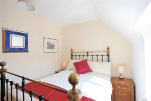 een slaapkamer met een bed met een rood kussen erop bij Springhill Cottage in Lyme Regis