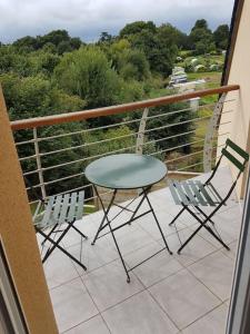 een tafel en 2 stoelen op een balkon bij Séjour inoubliable en Normandie Maison avec Spa in Valognes