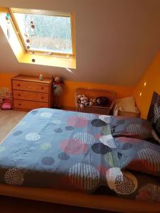 een slaapkamer met een bed met een blauw dekbed en een raam bij Séjour inoubliable en Normandie Maison avec Spa in Valognes