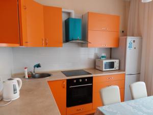 uma cozinha com armários laranja e um micro-ondas em Альтаир1 em Odessa