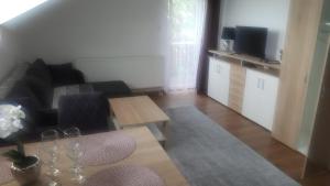 a living room with a couch and a table at Apartmán Zlatá rybka in Podhájska