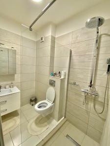 La salle de bains blanche est pourvue d'une douche et de toilettes. dans l'établissement Sea View Apartament, à Mamaia Nord – Năvodari