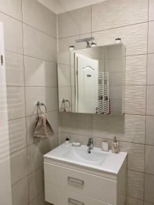 La salle de bains est pourvue d'un lavabo et d'un miroir. dans l'établissement Sea View Apartament, à Mamaia Nord – Năvodari