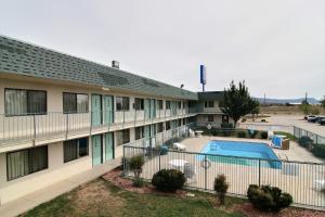 an apartment building with a pool and a parking lot at Travelodge by Wyndham Raton in Raton