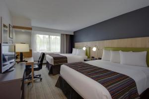 フレデリックにあるCountry Inn & Suites by Radisson, Frederick, MDのベッド2台とテレビが備わるホテルルームです。