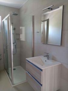 y baño con lavabo y ducha con espejo. en Vinisce Apartment 4, en Vinišće