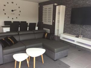 ein Wohnzimmer mit einem Sofa und einem TV in der Unterkunft Villa privative 3 chambres et piscine priv près Carcassonne in Carcassonne