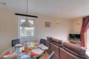 a dining room with a table and a couch at Undercliff in Lyme Regis