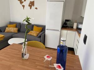 una sala de estar con una mesa con una botella azul. en Precioso Apartamento, luminoso, equipado en Torre de Benagalbón