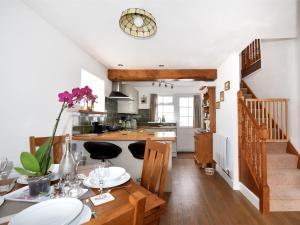 a kitchen and dining room with a table and a kitchen and stairs at Sunnyside in Colyton