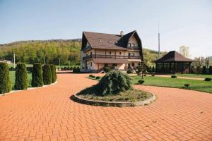 Pensiunea Miorița Putna في بوتنا: منزل كبير أمامه ممر من الطوب