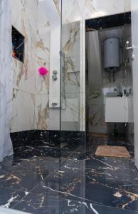 a bathroom with a glass shower and a sink at Guest House Eden in Bihać