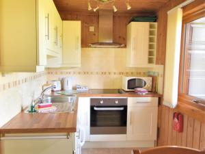 a kitchen with white cabinets and a sink at 4 Pinewood Retreat in Lyme Regis