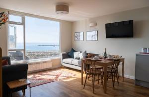 ein Wohnzimmer mit einem Tisch und einem Sofa in der Unterkunft 2 Beach Way House in Lyme Regis