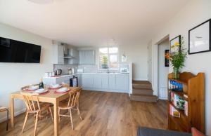 eine Küche und ein Esszimmer mit einem Tisch und Stühlen in der Unterkunft 2 Beach Way House in Lyme Regis