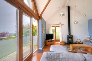 a living room with a couch and a large window at Pippin in Charmouth