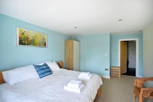 a bedroom with two beds with blue walls at Pippin in Charmouth