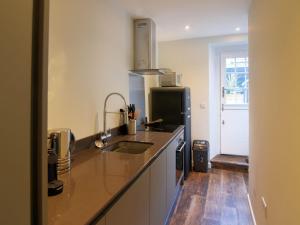 a kitchen with a sink and a refrigerator at Avocet in Lyme Regis