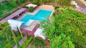 an overhead view of a swimming pool with tables and chairs at Casa Santa Teresita - Cabaña familiar tipo glamping in Sanarate