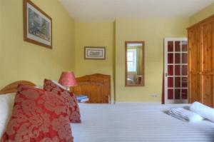 Schlafzimmer mit einem Bett mit einer roten und weißen Tagesdecke in der Unterkunft Radium in Lyme Regis