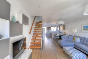 uma sala de estar com uma escada que leva a uma sala de estar em 3 Grove Mews em Seaton