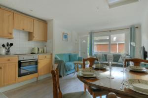 a kitchen and living room with a table and chairs at 36 Fernhill Heights in Charmouth