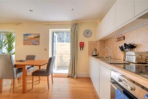 a kitchen with a table and a dining room at Seas The Day in Lyme Regis