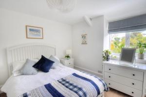 1 dormitorio con 1 cama, vestidor y ventana en 1 Lymbrook Cottages, en Lyme Regis