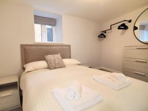 a bedroom with a bed with towels on it at Pebbles in Lyme Regis