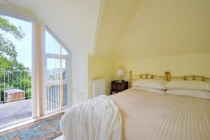 - une chambre avec un lit et une grande fenêtre dans l'établissement Oak Tree, à Lyme Regis