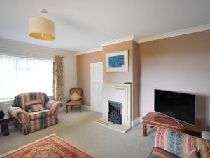un salon avec une cheminée et une télévision dans l'établissement Oak Tree, à Lyme Regis