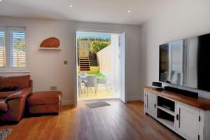 een woonkamer met een flatscreen-tv en een bank bij Shire View in Lyme Regis