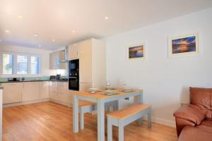 een keuken en een woonkamer met een tafel en een bank bij Shire View in Lyme Regis