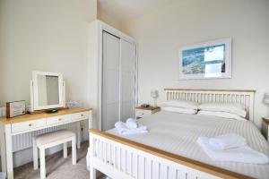 ein Schlafzimmer mit einem Bett, einer Kommode und einem TV in der Unterkunft Ocean View in Seaton