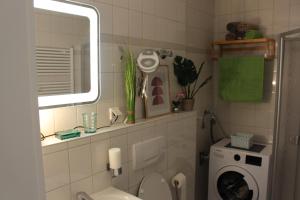 uma casa de banho com um WC e uma máquina de lavar roupa em Ferienwohnung Kassel West em Kassel