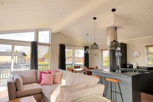 a living room with a couch and a kitchen at Hazelwood 4 Pinewood Retreat in Lyme Regis