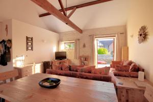 ein Wohnzimmer mit einem Sofa und einem Tisch in der Unterkunft 2 Home Farm South in Lyme Regis