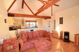 a living room with a couch and a kitchen at 2 Home Farm South in Lyme Regis