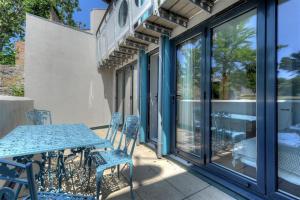 een blauwe tafel en stoelen op een patio met een raam bij No 2, 26 Broad Street in Lyme Regis