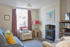 un salon avec un canapé et une cheminée dans l'établissement Lavender Cottage, à Beer