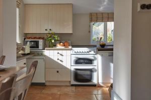 une cuisine avec une cuisinière et un micro-ondes dans l'établissement Lavender Cottage, à Beer 17 autres photos
