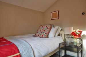 une chambre avec un lit et une table avec des fleurs dessus dans l'établissement Lavender Cottage, à Beer