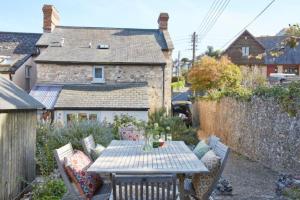 - une table et des chaises dans l'arrière-cour d'une maison dans l'établissement Lavender Cottage, à Beer