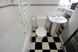 un baño con inodoro y lavabo en Driftwood, en Lyme Regis 7 fotos más