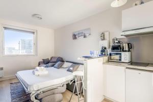 a kitchen with a couch and a table in a room at Nice studio with seaview in Deauville port - Welkeys in Deauville