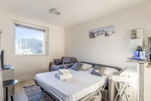 a small bedroom with a bed and a chair at Nice studio with seaview in Deauville port - Welkeys in Deauville