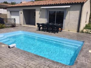 ein blauer Pool vor einem Haus in der Unterkunft Villa privative 3 chambres et piscine priv près Carcassonne in Carcassonne