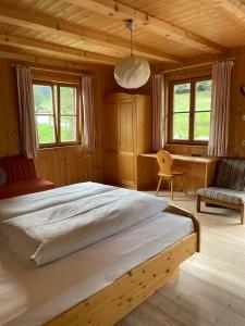 a bedroom with a large bed and a desk at Edelweißhütte in Funes